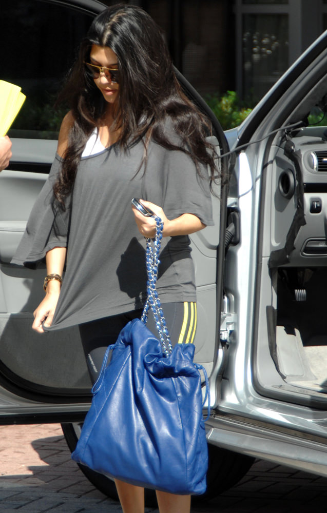 Kourtney Kardashian carrying a Prada diaper bag, takes her