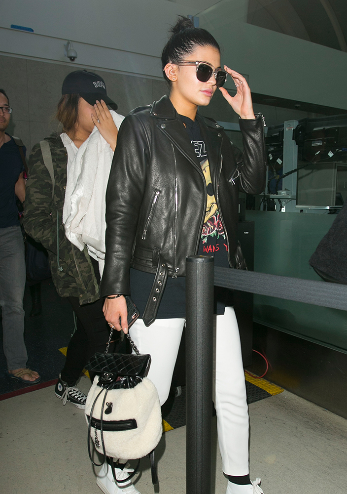 Kylie Jenner slings Louis Vuitton bag over her Rasta jacket as she jets out  of LAX